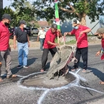 Ketua DPC PDIP Kabupaten Kediri Murdi Hantoro (dua dari kiri) dan Ketua PAC Kecamatan Pagu (kiri) saat ikut turun menambal jalan berlubang dengan semen. foto: MUJI HARJITA/ BANGSAONLINE