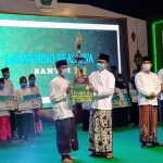 Bupati Pamekasan Baddrut Tamam menyerahkan trofi kepada juara lomba video pendek dalam acara Peringatan Maulid Nabi di Lapangan Nagara Bhakti, Mandhapa Agung Ronggosukowati Pamekasan. 