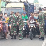 Relawan Gus Barra dibantu TNI saat bagi-bagi takjil kepada pengendara di Raya Kemlagi.