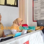 Sekretaris Disnaker Kabupaten Kediri, Djumadi, saat berdialog dengan salah satu calon PMI. Foto: MUJI HARJITA/BANGSAONLINE