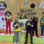Ketua KONI Gresik, Anis Ambiyo Putri (kiri), bersama para atlet IBCA MMA peraih medali. Foto: Ist