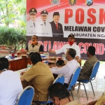 Bupati Ngawi Budi Sulistyono (memakai topi) memimpin rapat evaluasi dan penetapan Ngawi sebagai kawasan wajib masker di Pendopo Paseban Pemkab Ngawi, Senin (20/04).