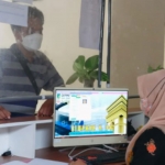Petugas IT di Desa Pelem, Kecamatan Pare, Kabupaten Kediri, Sinta Aprilia Sari, saat melayani warga yang hendak mengurus dokumen kependudukan. Foto: Ist