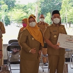 Bupati Gus Yani didampingi Wabup Bu Min saat menyerahkan sertifikasi kepada salah satu UMKM. (foto: SYUHUD/BANGSAONLINE)