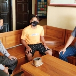 Pelaku (tengah) saat berada di Kantor Polsek Gondang untuk menjalani pemeriksaan akibat perbuatanya. foto: BAMBANG/ BANGSAONLINE