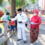 Kapolresta Sidoarjo Kombes Pol Sumardji didampingi istri saat membagikan masker ke salah satu warga.