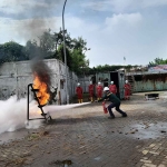 Peserta lomba Balakar Tjiwi Kimia praktek memadamkan api, Selasa (24/1/2023). Foto: Mustain/BANGSAONLINE.com