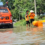 Petugas BPBD Jombang menyiapkan perahu karet di lokasi banjir. foto: AAN AMRULLOH/ BANGSAONLINE