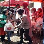 Anggota polisi ikut membantu pembagian bingkisan DNY Skincare, Sabtu (14/3/2026). Foto: MUSTAIN/ BANGSAONLINE