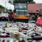 Ratusan botol miras ilegal yang diamankan saat operasi pekat dimusnahkan dengan cara dilindas.