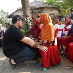 Calon Bupati Kediri nomor urut 2 Hanindhito Himawan Pramana saat bersimpuh di hadapan seorang Ibu. Foto: Ist.