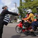 Petugas dari Dinkes Kota Kediri yang berpakaian unit saat membagikan brosur kepada pengguna jalan. Foto: Ist