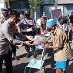 Wakapolres Kediri Kompol Anggi Saputra Ibrahim saat menyerahkan bantuan beras kepada salah satu warga di Posko Gusdurian Mojokutho Pare. (foto: ist)