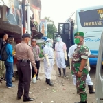 Petugas gabungan TNI-Polri dan Pukesmas Kandangan tampak memakai APD lengkap saat mengevakuasi korban ke mobil ambulans. foto: ist.