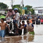 Saat banjir menggenangi kawasan Kraton Pasuruan, dimanfaatkan warga menyediakan jasa menyeberangkan motor. foto: tempo