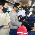 Wabup Nur Ahmad dan Kombes Pol Sumardji sedang membagikan masker kepada para penumpang bus di Terminal Bungurasih.