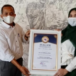 Direktur Eksekutif ARCI, Baihaki Siradj menyerahkan piagam penghargaan kepada Dr. Lia Istifhama sebagai Tokoh Muda Peduli Covid-19 dalam ARCI Awards 2020. foto: ist.