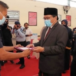 Kepala Lapas Kelas IIB Kota Pasuruan, Wahyu Indarto saat menyerahkan remisi kepada salah satu warga binaan secara simbolis.