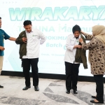 VP Pengelolaan Transformasi Bisnis Petrokimia Gresik Grastayana Suki (kiri) memakaikan jaket kepada Taruna Makmur saat akan diberangkatkan ke berbagi daerah. Foto: ist.