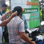 H Sholahuddin saat memasang masker ke salah satu pengendara motor.