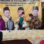 Tampak Ketua DPD Golkar Kabupaten Pasuruan Drs. H. Udik Djanuantoro, IR (tiga dari kanan), saat menyalurkan sembako secara simbolis.