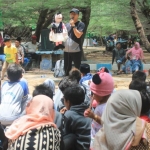 Kak Avan, Relawan Rumah Cerita OKARA saat membawakan dongeng di Pantai Lombang.