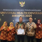 Wakil Bupati Gresik didampingi Kepala Dinkes Gresik ketika menunjukkan penghargaan Madya UHC Awards 2026. Foto: Ist