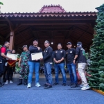 Ketua KWG Miftahul Arif menyerahkan penghargaan kepada Plt Bupati Gresik Asluchul Alif di festival  Nasi Krawu. Foto: Ist.
