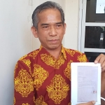 Agus Priyono menunjukkan bukti anaknya keluar dari perusahaan di Pasuruan setelah dijanjikan AT bisa lolos PPPK di Dishub Gresik. Foto: SYUHUD/BANGSAONLINE