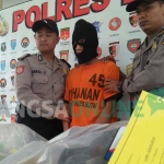 Ari Nurjaman, pelaku pembacokan Sugeng Alias Bagong, bersama sejumlah barang bukti yang diamankan polisi. foto: AKINA/ BANGSAONLINE