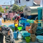 Petugas Polres Gresik saat mengirim air bersih di sekitar Kecamatan Duduksampeyan. Foto: SYUHUD/BANGSAONLINE
