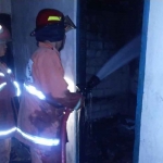 Petugas Damkar Gresik ketika memadamkan rumah korban yang terbakar. Foto: Ist