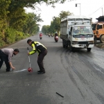 Petugas kepolisian saat melakukan olah TKP di Jalan Raya Prambon, Sidoarjo.