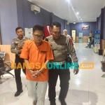 Tersangka pengemudi mercy maut yang tabrak 6 kendaraan di Jalan Kenjeran Surabaya saat digelandang ke sel sementara. Foto: Rusmiyanto/BANGSAONLINE