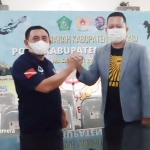Bambang Pujianto (kiri) bersalaman dengan M Ridho Prasetyo, usai terpilih aklamasi sebagai Ketua POSSI Sidoarjo.