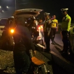 Anggota Satlantas Polres Lamongan saat hendak mengamankan motor yang akan digunakan untuk balap liar. 