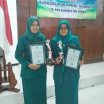 Ibu Camat Senori, Ny. Rita Sahara didampingi ibu Kades Desa Jatisari, Ny. Faizah Setiawan menunjukkan piagam penghargaan.