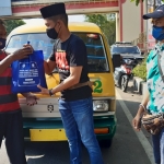 BERBAGI: PWI Sidoarjo membagikan sembako ke sopir angkot, di Jalan Jenggolo, Sidoarjo, Jumat (30/4/2021). foto: MUSTAIN/ BANGSAONLINE