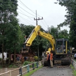 Petugas dari DPUPR Jombang saat bersihkan tumpukan sampah di Afvoer Watudakon.