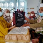 Ustadz Choliq Idris saat menyerahkan cinderamata berupa al-Quran, mukena, dan buku tentang Islam kepada Ika Sari Wijayanti usai ikrar dua kalimat syahadat di Masjid Nasional Al-Akbar Surabaya, Jumat (26/2/2021). Foto: MMA/ BANGSAONLINE.COM