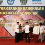 Kepala Dinas Pendidikan Dr. Bambang Mustika menyerahkan buku pentunjuk teknis Gerakan Bangkalan Menghafal Alquran (GBMQ) kepada Bupati Bangkalan R. Abdul Latif Imron Amin.