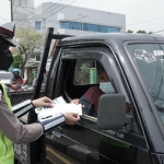 
Petugas Satlantas Polres Gresik saat membagikan masker kepada pengendara. foto: SYUHUD/BANGSAONLINE.com