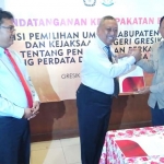 Kajari Pandu Pramukartika dan Ketua KPU Ahmad Roni menunjukkan MoU. foto:  SYUHUD/ BANGSAONLINE