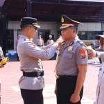 Kapolres Ngawi, AKBP Dwi Sumrahadi Rakhmanto saat menyematkan lencana kepada salah satu personelnya dalam kegiatan upacara kenaikan pangkat pengabdian anggota Polri, di Halaman Satya Haprabu polres setempat, Selasa (1/10/2024).