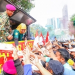 Gubernur Jawa Timur, Khofifah Indar Parawansa, menyapa masyarakat yang menghadiri perayaan Indonesian Marines Day dalam rangka Hari Ulang Tahun ke-80 Korps Marinir TNI Angkatan Laut yang digelar di sepanjang Jalan Pemuda depan Grahadi dan Taman Apsari Surabaya, Minggu (9/11/2025).