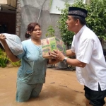 Gus Syaf menyerahkan bantuan untuk korban banjir di Desa Gambiran, Kecamatan Mojoagung. foto: BANGSAONLINE