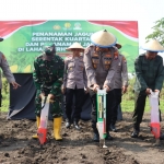 Kapolres Mojokerto Kota AKBP Herdiawan Arifianto saat melakukan penanaman jagung serentak kuartal III di Desa Gunungsari, Kecamatan Dawarblandong, Rabu (9/7/2025).