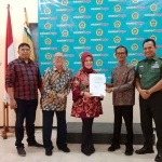 Kepala Lembaga Layanan Dikti Wilayah VII, Dyah Sawitri (tengah), saat menyerahkan SK pencabutan sanksi pembinaan Universitas Merdeka Surabaya.