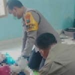 Petugas Polres Blitar saat memeriksa tubuh korban.