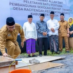 Sekdakab Gresik Achmad Washil Miftahul Rachman saat meletakkan batu pertama sebagai tanda dimulainya pembangunan Sekolah Rakyat di Desa Raci Tengah, Kecamatan Sidayu. Foto: Ist